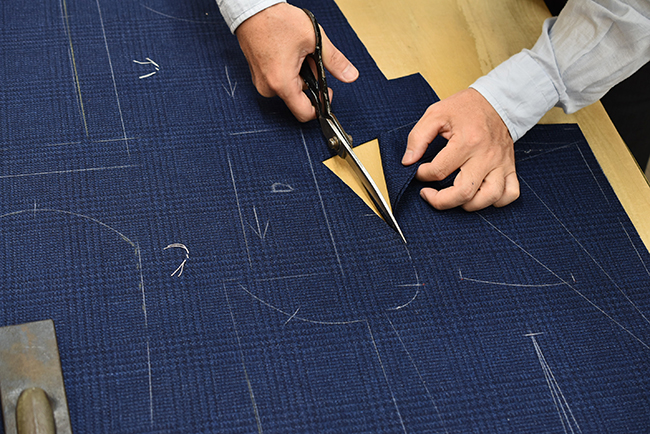 裁ちばさみでラペル周辺を手裁ちしている手元。Zegna生地のネイビー。 (手裁ちカット その2)